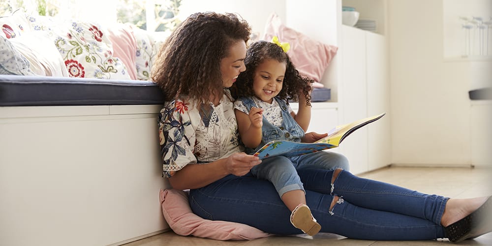 A mother and daughter spend time together reading a book